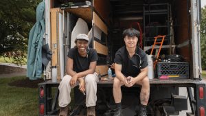 cinema students sitting on back of moving truck