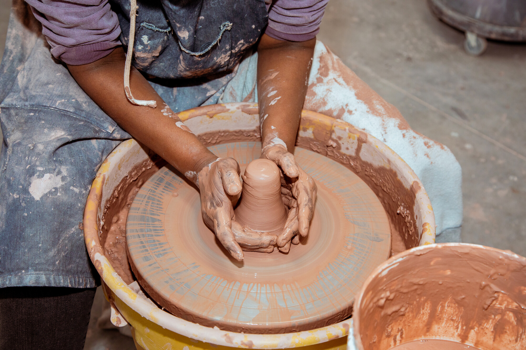 student making clay pottery