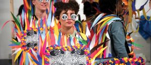 Students pose in colorful handmade paper costumes made of multicolor triangles