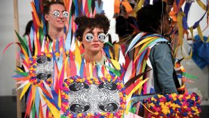 Students pose in colorful handmade paper costumes made of multicolor triangles