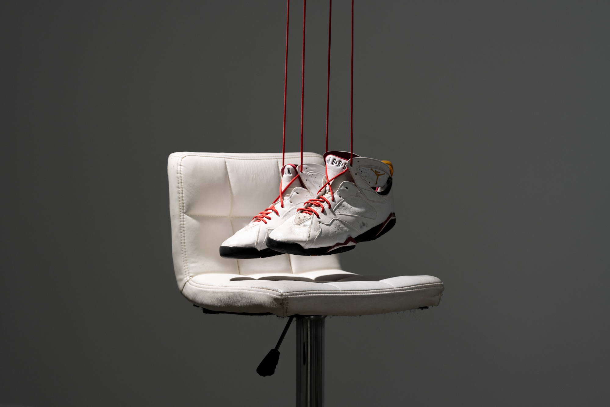 Michael Jordan sneakers suspended above a white barstool