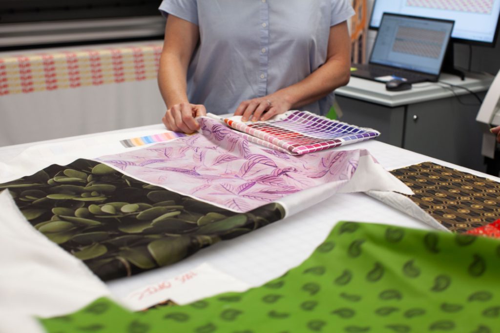 close up shot of printed fabric on a table with someone holding up the fabric