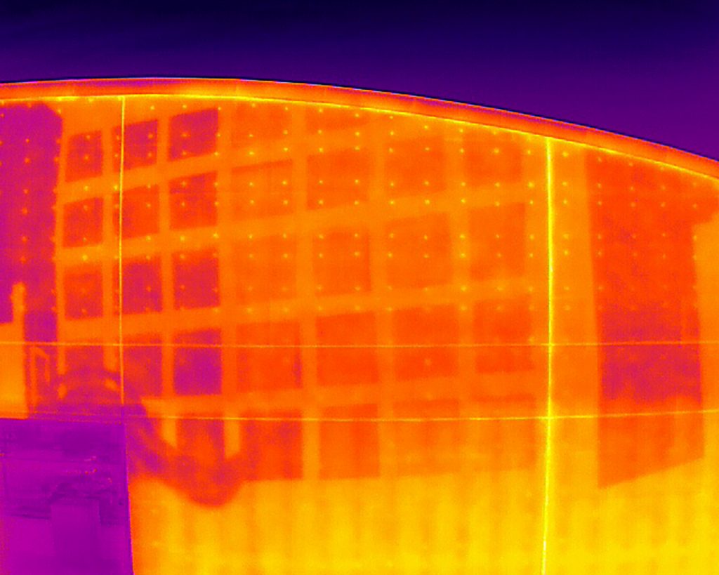 A thermal infrared camera image showing the temperature differences in Sirena Pearl's mural, displaying the warmer temperatures of the mural as a bright yellow and the cooler areas as a dark purple to visualize the urban heat island effect that increases energy costs, pollution and heat-related illnesses.