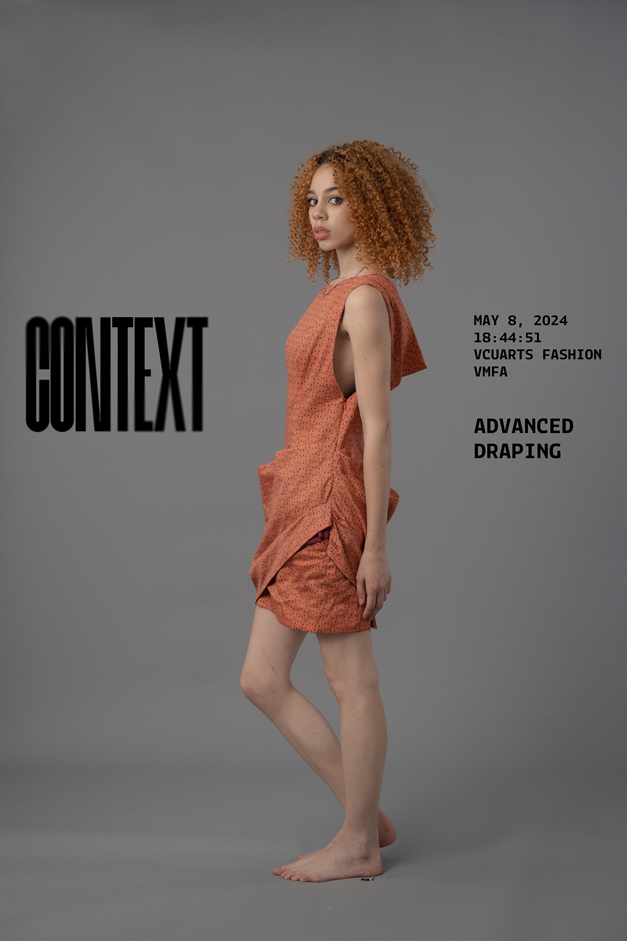 Garment documentation of a model with curly spirals of red hair wearing a red draped dredd