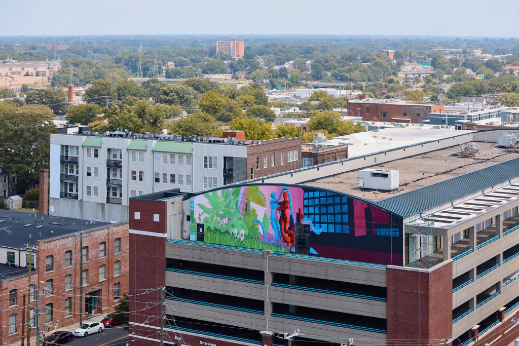 Sirena Pearl's mural painted above the Bowe Street parking deck featuring two worlds personified as figures representing the complex and chaotic ecological systems of humans and the environment. 