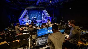 audio engineer operating sound board at theatre production