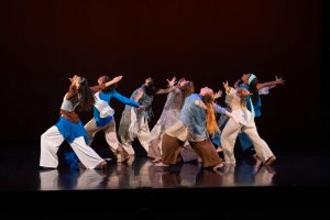 Students performing a dance at INTER9 on a dark stage with red lighting