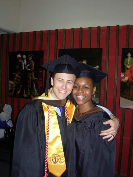 two people in cap and gown smiling 