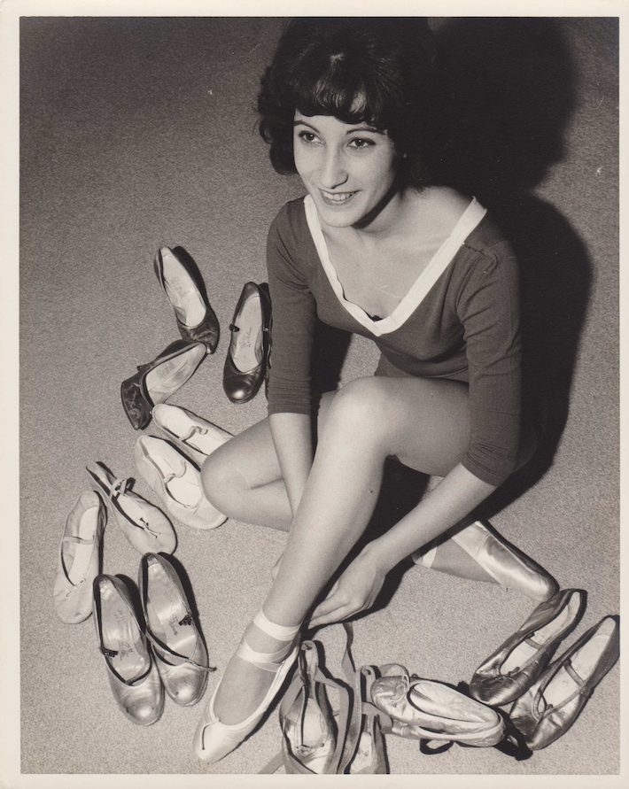 woman posing with ballet shoes