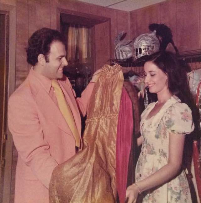 man and woman holding up robe and smiling