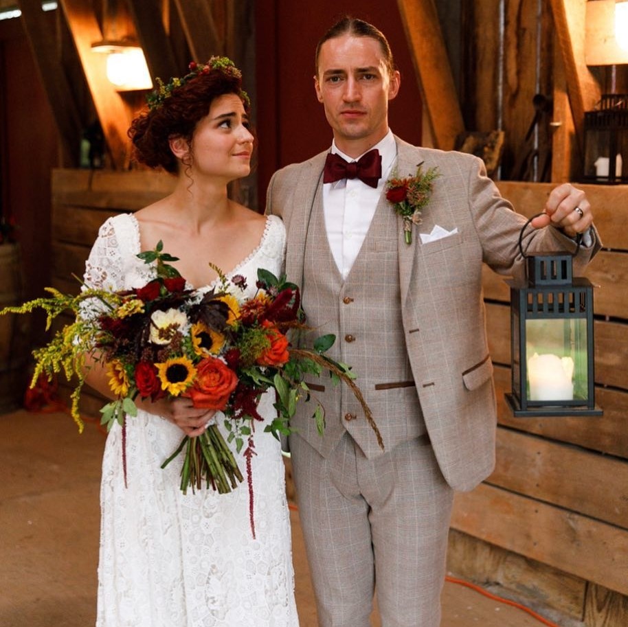 man and woman in wedding attire with arms around each other