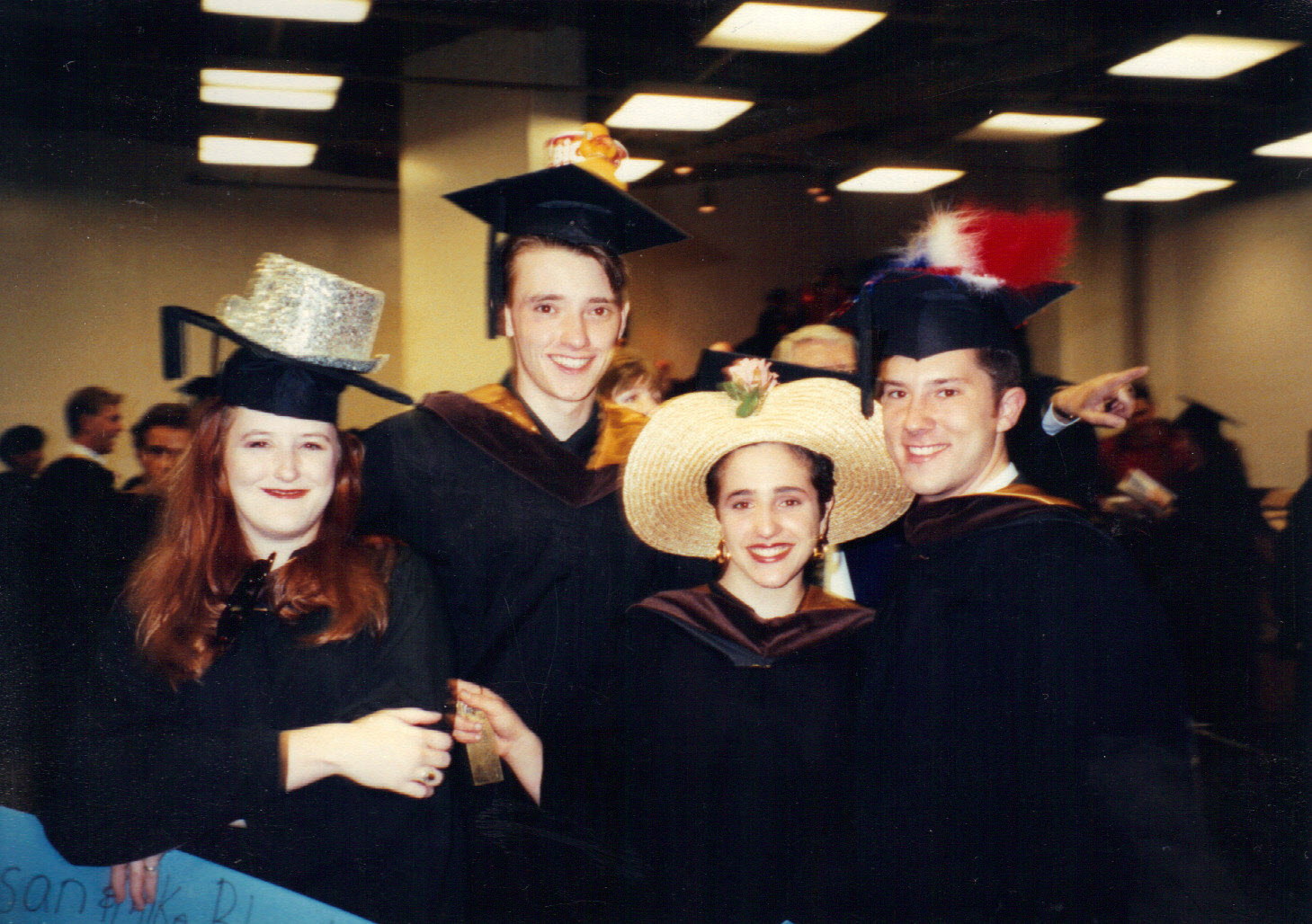 four people in cap and gown smiling