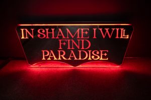 glowing red sign that reads in shame i will find paradise