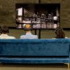 people sitting on couch viewing digital exhibit displayed on television