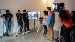 students filming in a studio with lighting