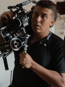 Cinema student holding video camera on set