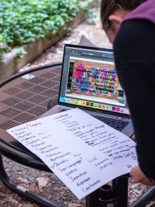 graphic design student working on laptop designing a colorful mural