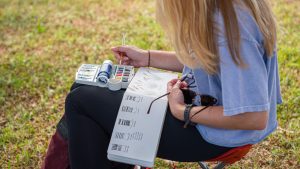 Student sketching in notebook outside