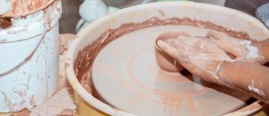 A detail of hands shape clay on a pottery wheel