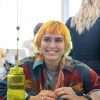 A smiling student with brightly colored hair