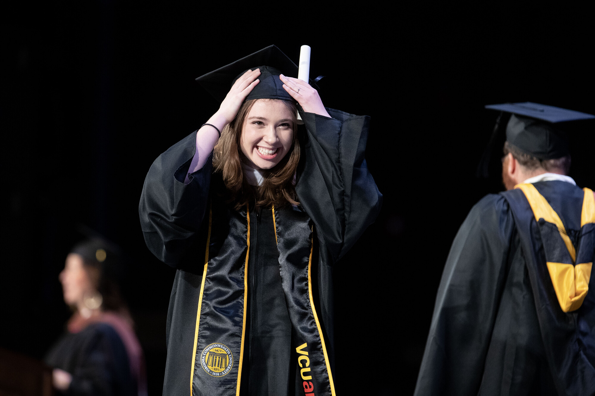 A smiling graduate with her diploma