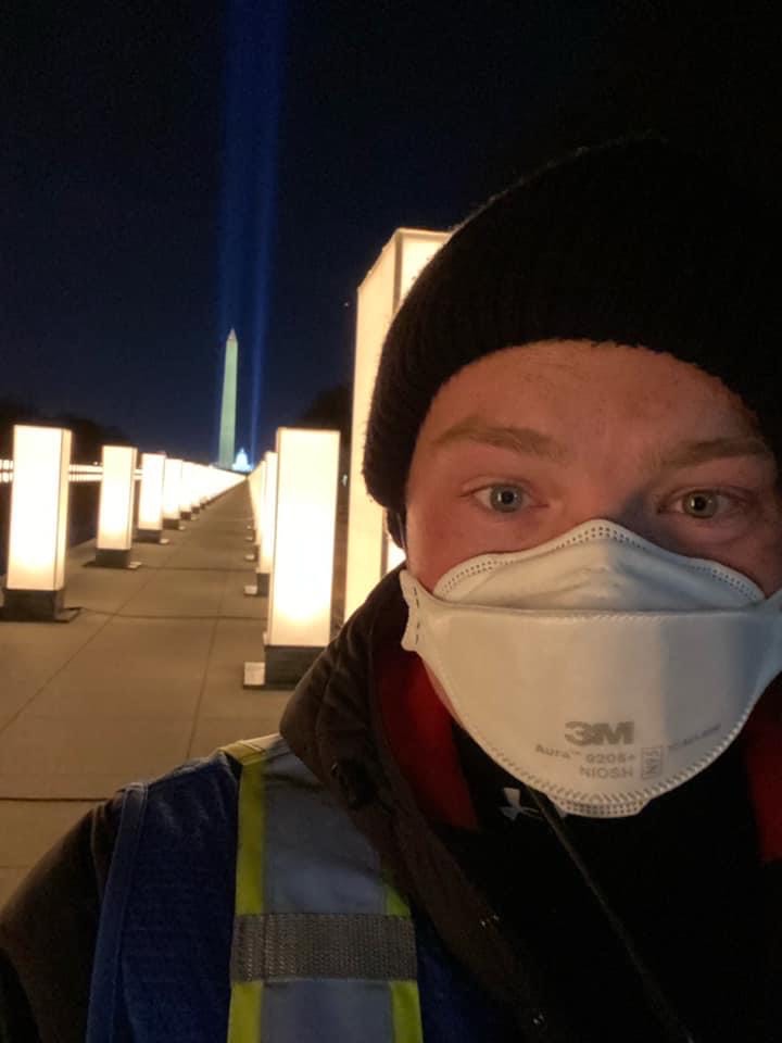 man wearing mask and standing in front of lights 