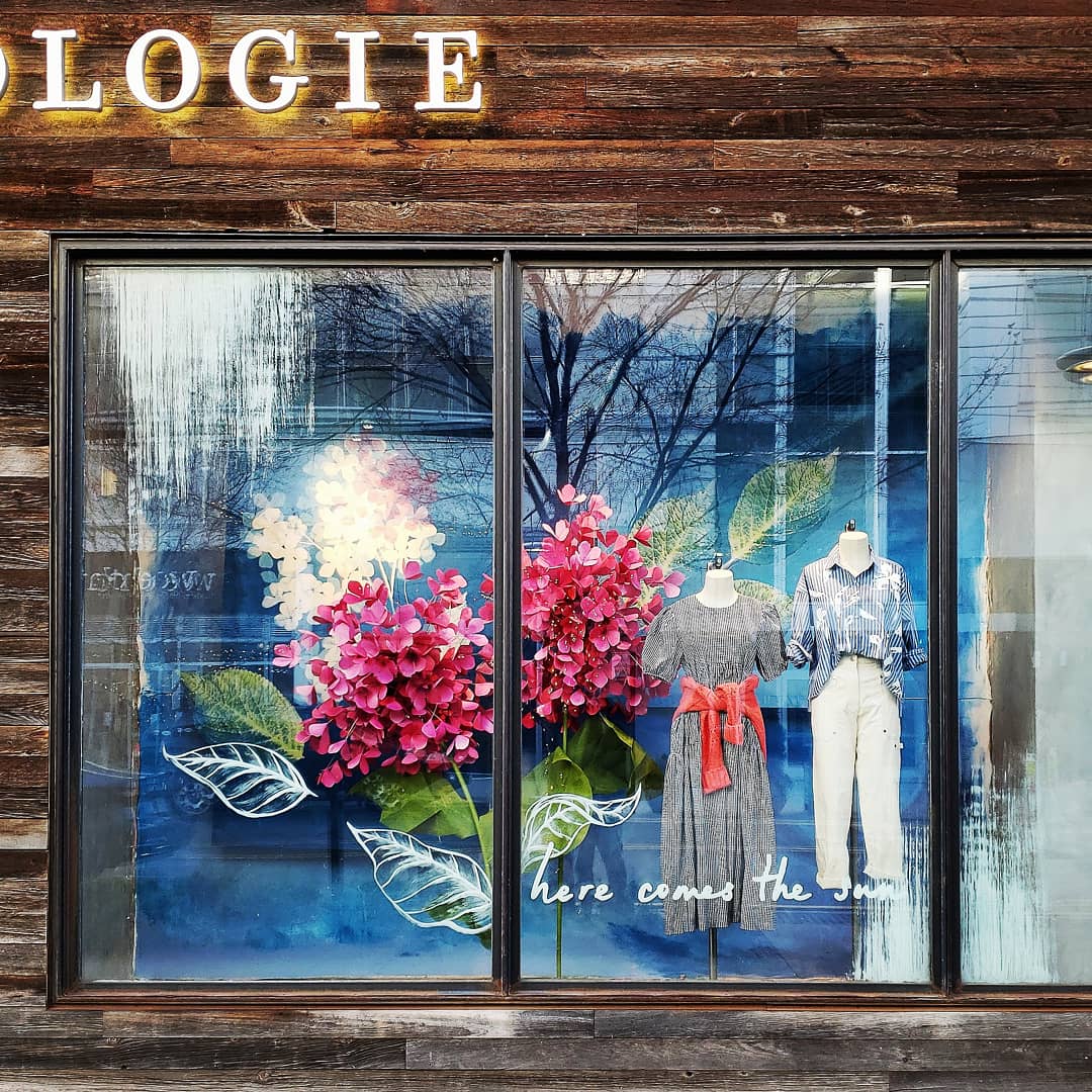 an anthropologie store display with flowers and clothes