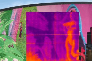 A thermal infrared camera image showing the temperature differences in Sirena Pearl's mural, displaying the warmer temperatures of the mural as a bright yellow and the cooler areas as a dark purple to visualize the urban heat island effect that increases energy costs, pollution and heat-related illnesses.