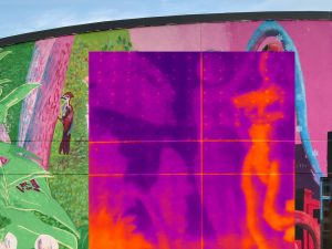 A thermal infrared camera image showing the temperature differences in Sirena Pearl's mural, displaying the warmer temperatures of the mural as a bright yellow and the cooler areas as a dark purple to visualize the urban heat island effect that increases energy costs, pollution and heat-related illnesses.