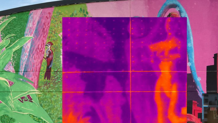 A thermal infrared camera image showing the temperature differences in Sirena Pearl's mural, displaying the warmer temperatures of the mural as a bright yellow and the cooler areas as a dark purple to visualize the urban heat island effect that increases energy costs, pollution and heat-related illnesses.