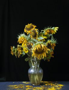 A vase filled with vibrant yellow flowers, elegantly arranged as a centerpiece on a table, showcasing the beauty of floristry and floral design.