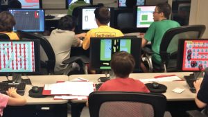 young students playing video games on computer