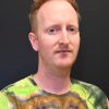 A man with red hair looks at the camera.