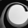 The viewer is looking at the inside of a wooden sculpture that is cylindrical and spiraling.