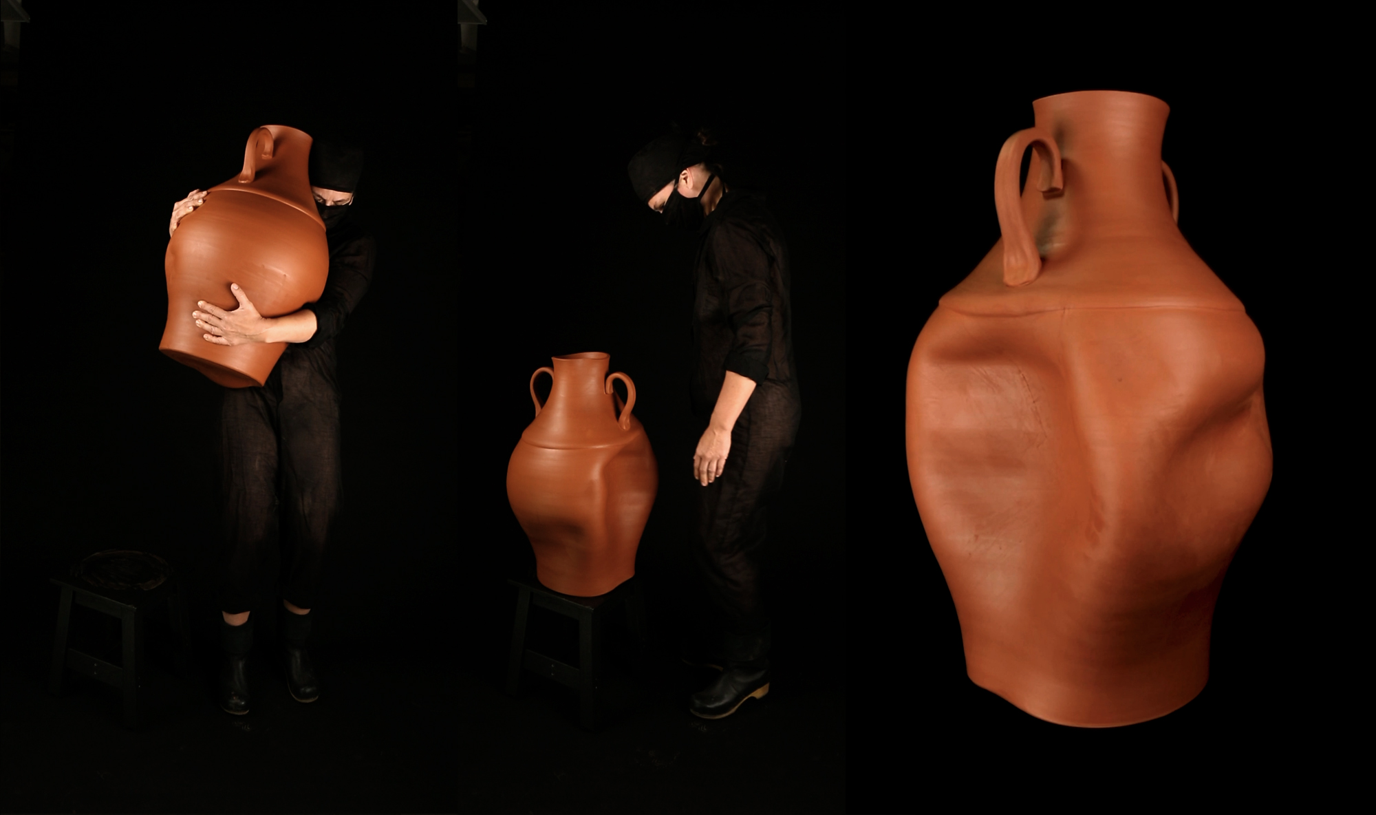 There are three large terracotta vases lined up from left to right in front of a black ground. There is one person in black clothing holding up the left-most vase, and there is a person dressed in black clothing standing next to the middle vase, looking down at it. The right-most vase is the same height as the person standing in the middle.